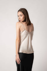 Woman wearing champagne silk camisole top and black skirt. Back view. Pure silk with a bias cut