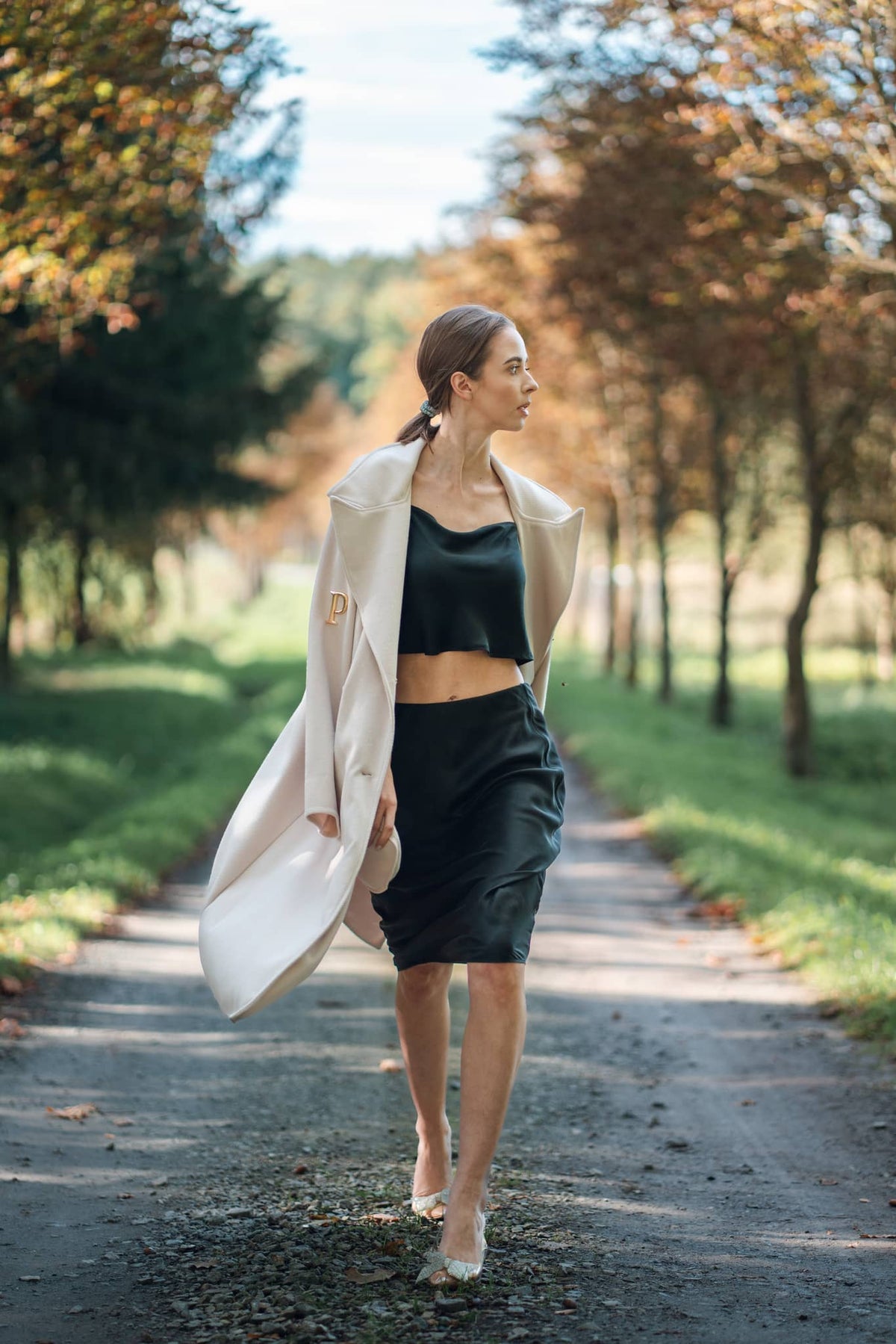 Model wearing Silk Closet black midi skirt and black crop blouse outdoors