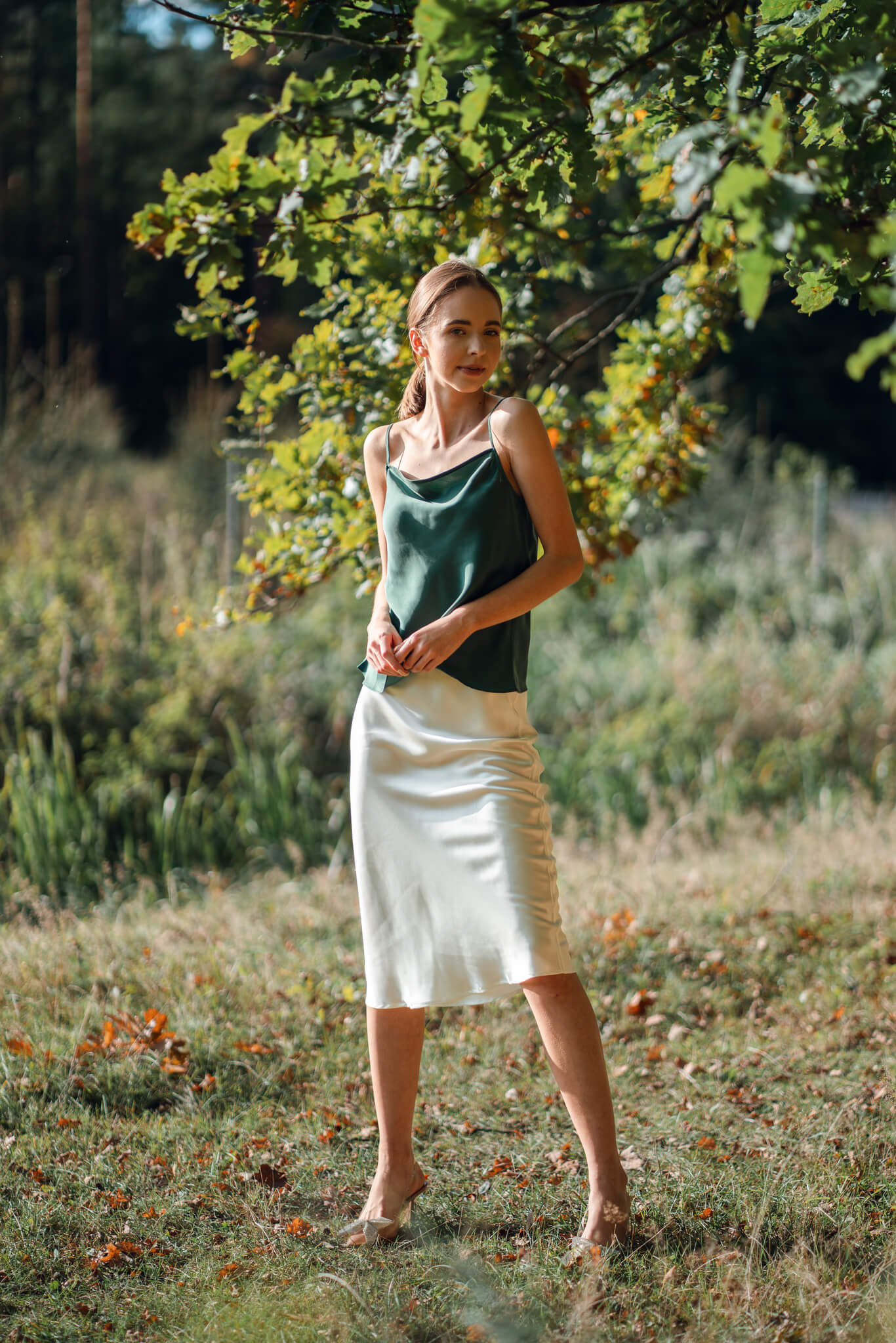 Woman wearing Silk Closet green camisole and ivory silk slip skirt outdoors.