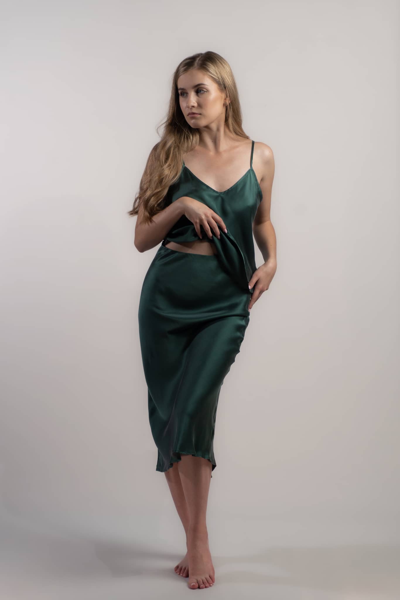 Woman wearing silk closet green skirt and camisole top. Perfect for evenings.