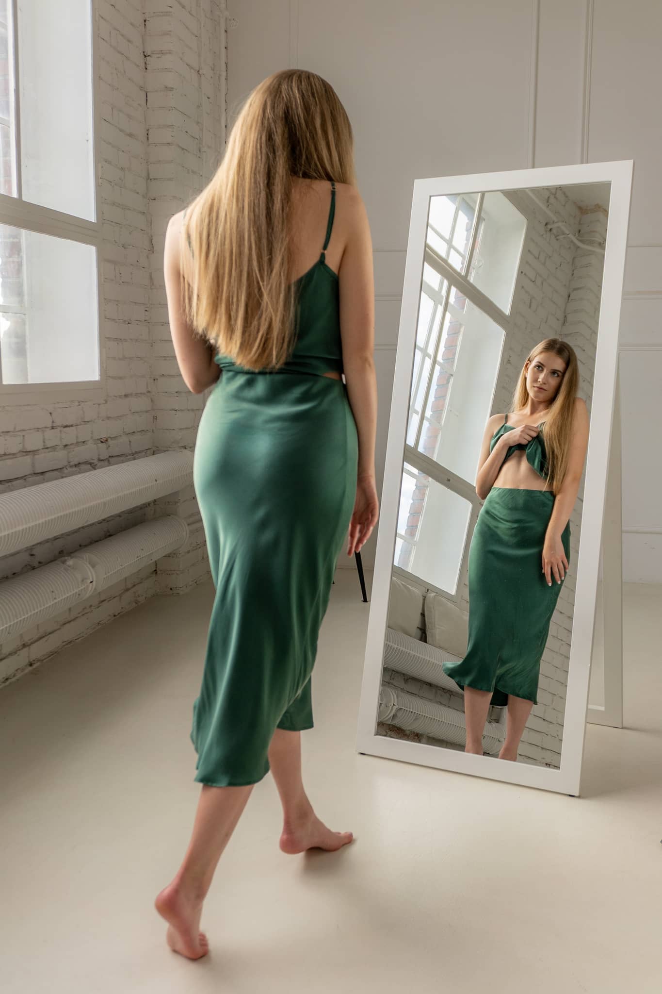 Woman wearing silk closet green skirt and camisole top. Luxury outfit.