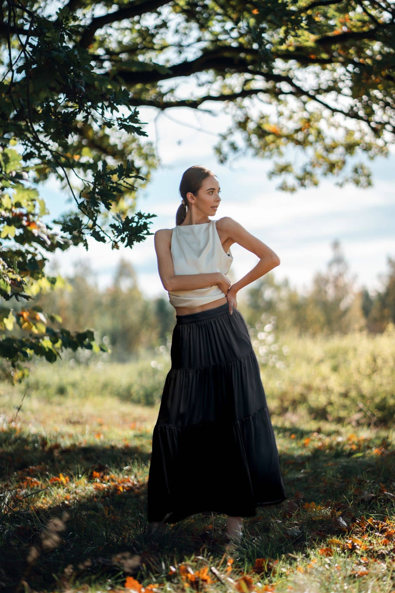 Woman wearing black maxi skirt. Silk long skirt with tiers.