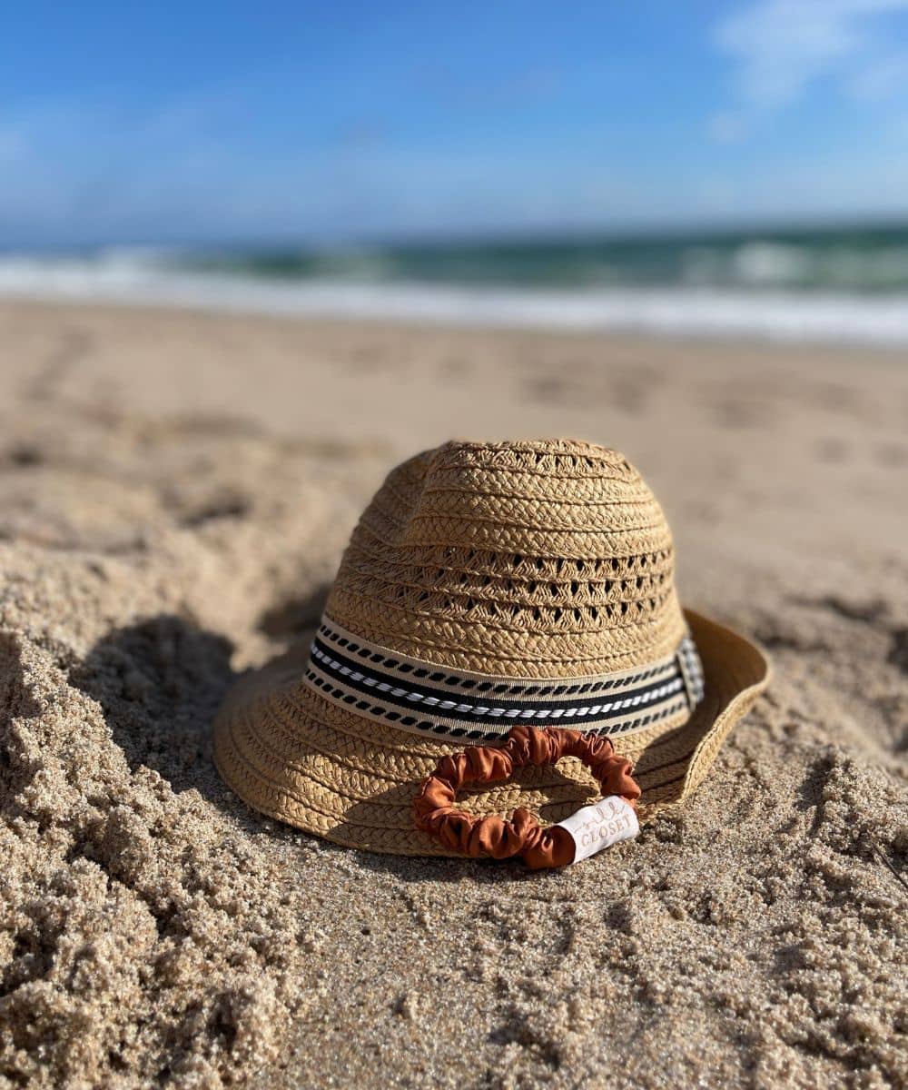 Orange russet silk hair scrunchie in midi size at beach with hat