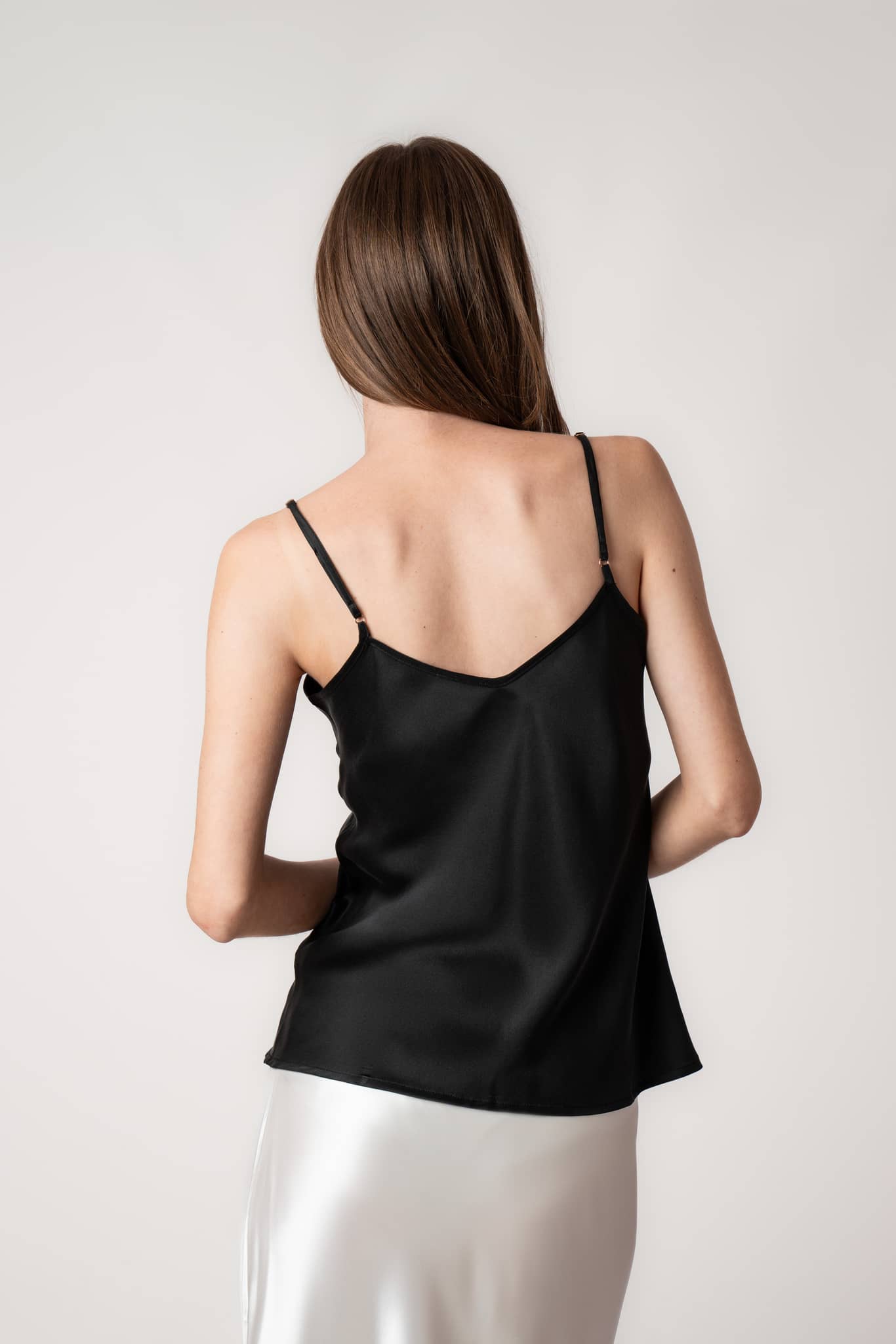 Model wearing black silk camisole top by Silk Closet back view.