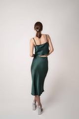Woman wearing silk closet green skirt and camisole top. Back View