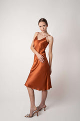 Woman wearing orange silk Closet classic dress in studio