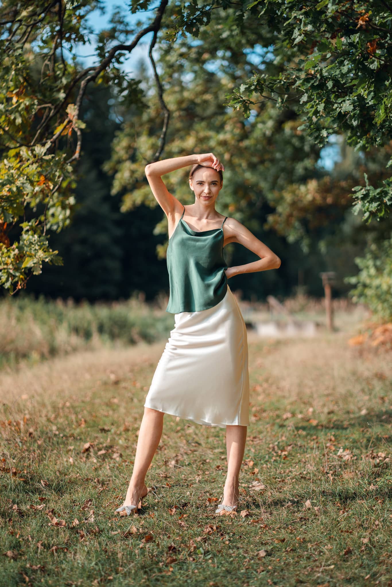 Woman wearing Silk Closet green camisole and ivory silk slip skirt outdoors in nature.