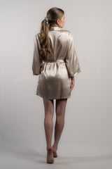 Woman wearing champagne silk robe or kimono. Pure silk. Perfect for special events such as weddings. Back view.