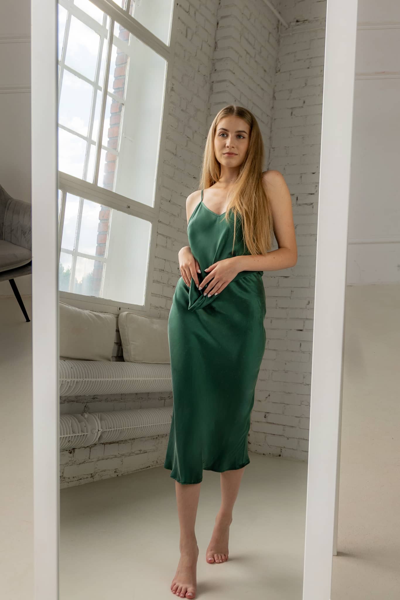 Woman wearing silk closet green skirt and camisole top. Mirror. Luxury silk.