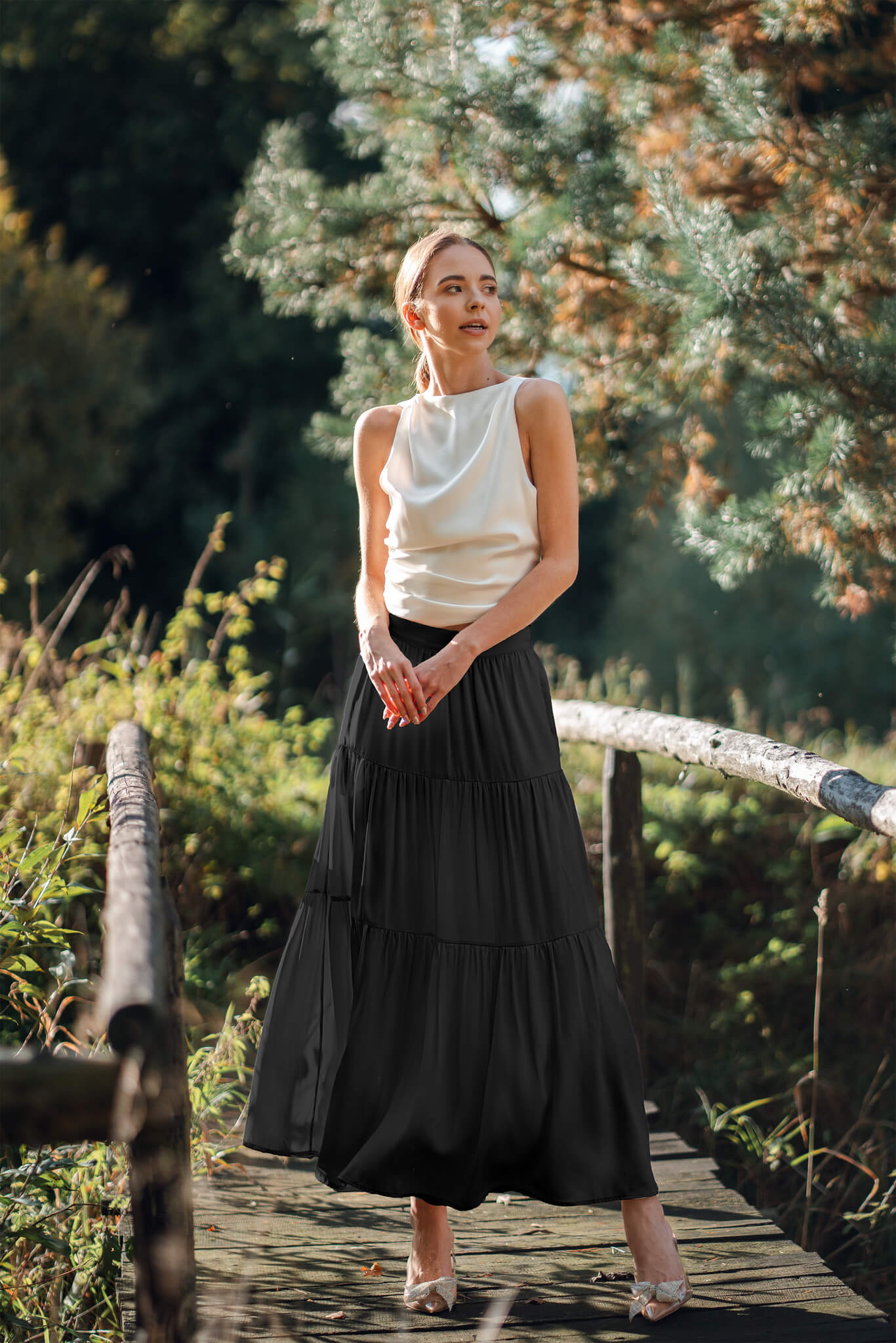 Woman wearing Silk Closet tiered Maxi skirt in sandwash black outdoors. Boho and whimsical