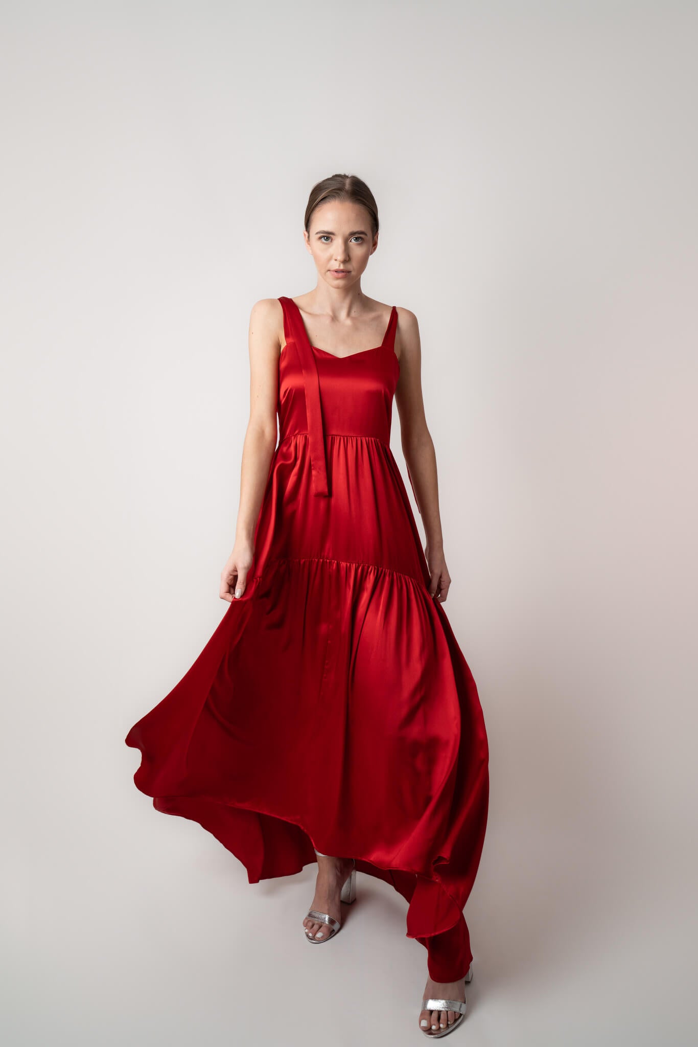 Beautiful red silk maxi dress with tiers and bows in studio