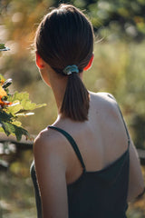 Woman wearing Silk Closet green camisole and scrunchie. Back